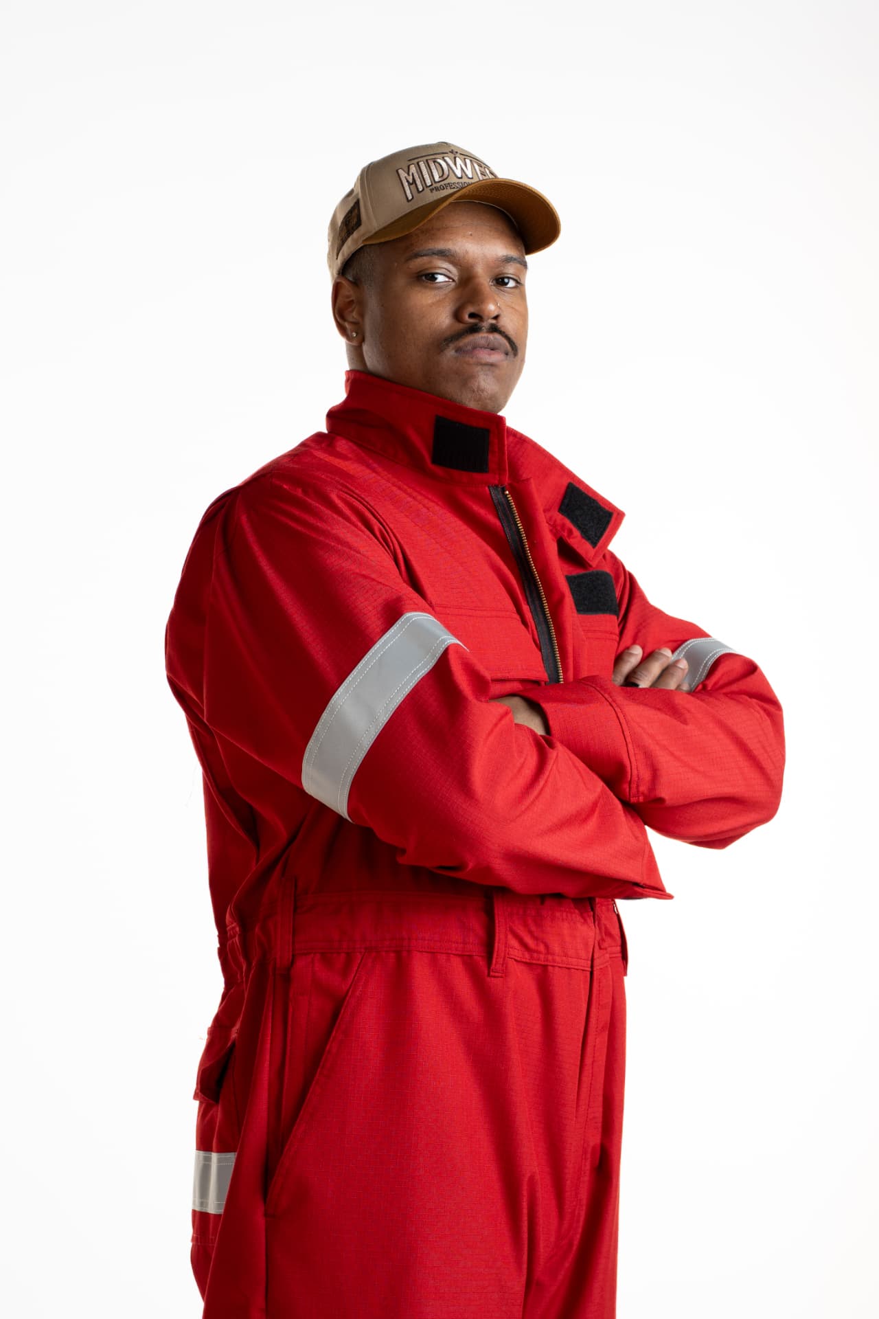 Professional portrait of a person in a red coverall on a clean white studio background