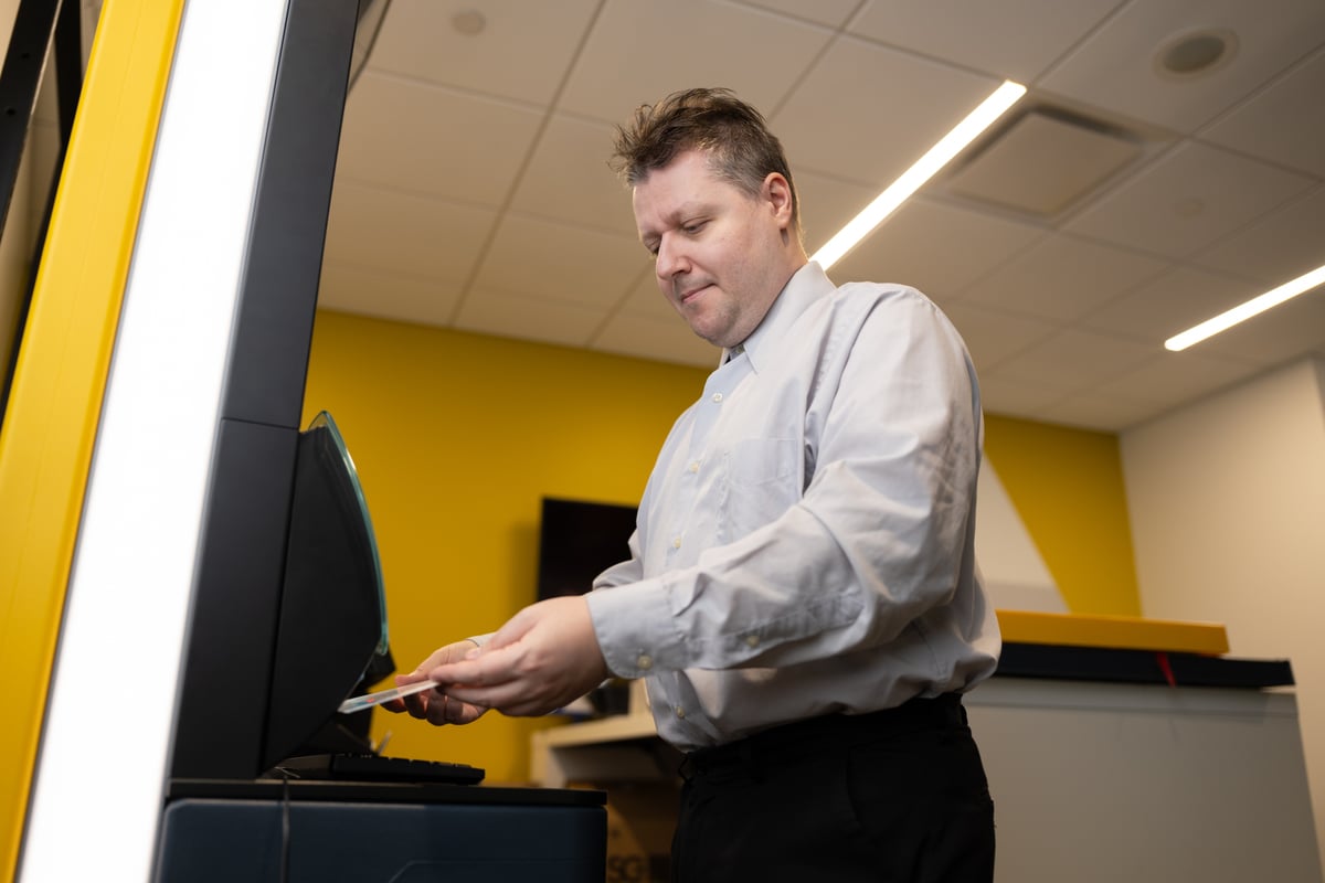 Employee working at a service counter, photographed on location for a corporate brand