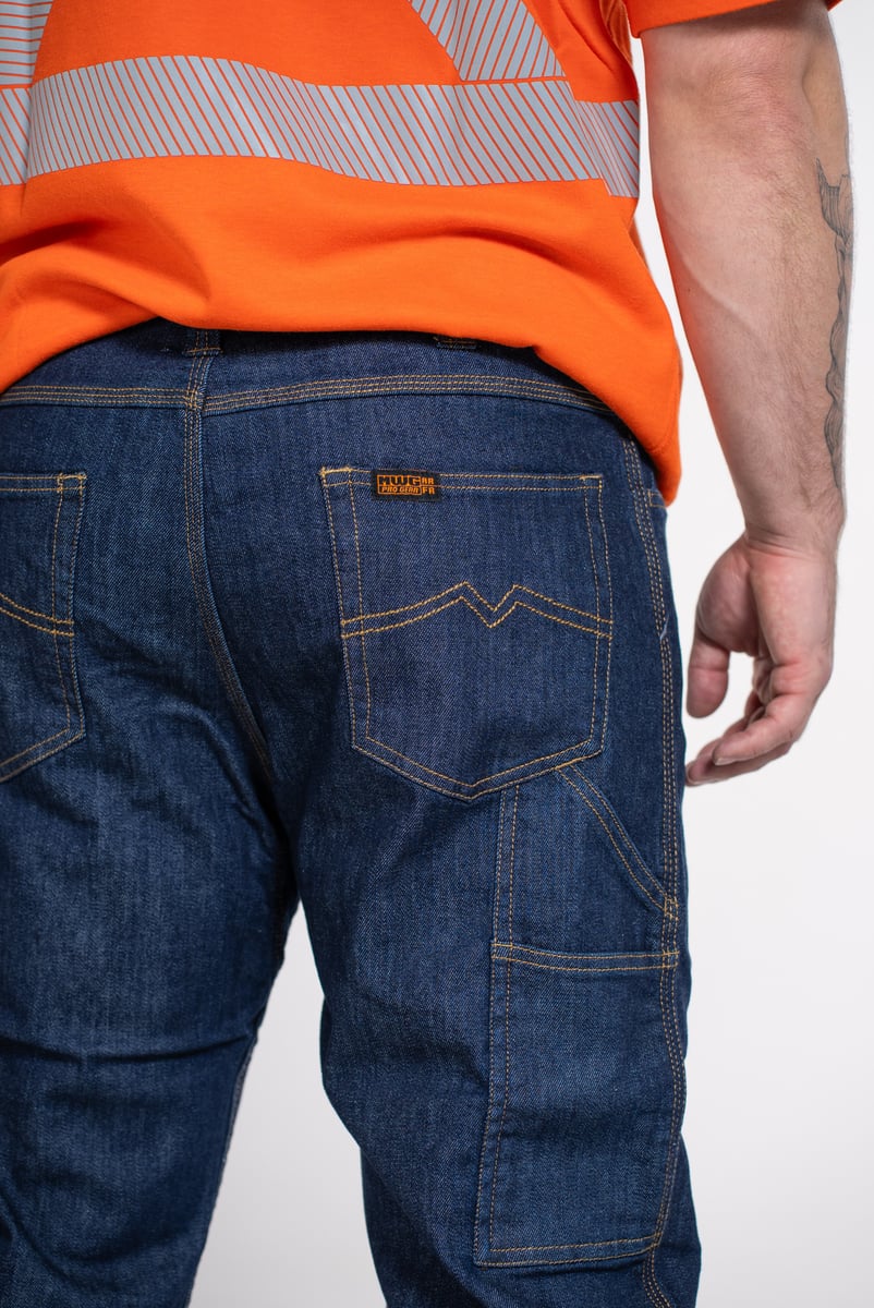 Detail e-commerce photo of denim work jeans paired with an orange hi-vis shirt