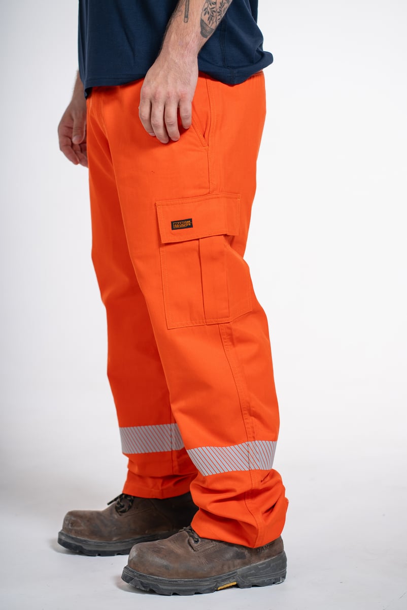 Studio product photo of orange hi-vis work pants with reflective striping