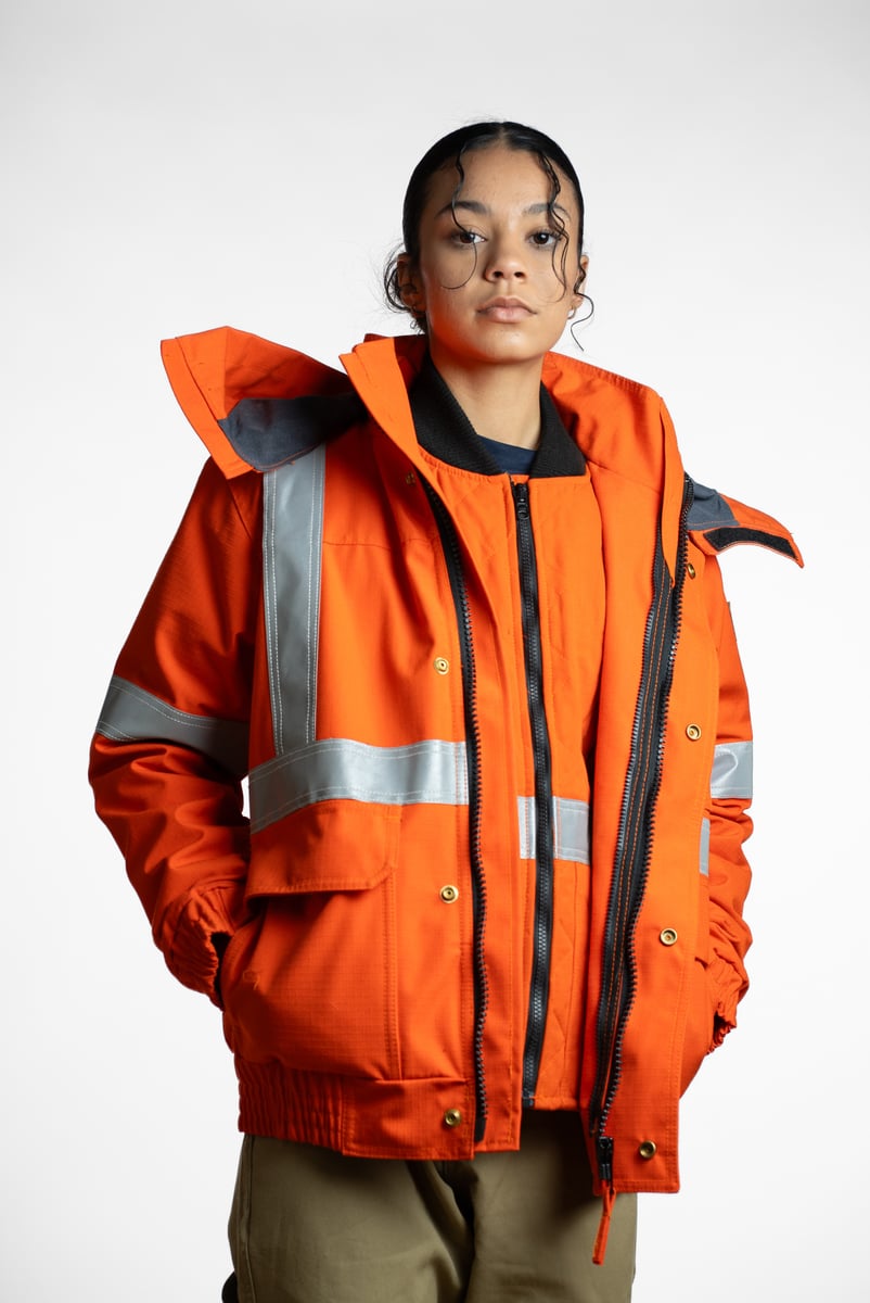 E-commerce studio photo of a high-visibility orange insulated work jacket on a model